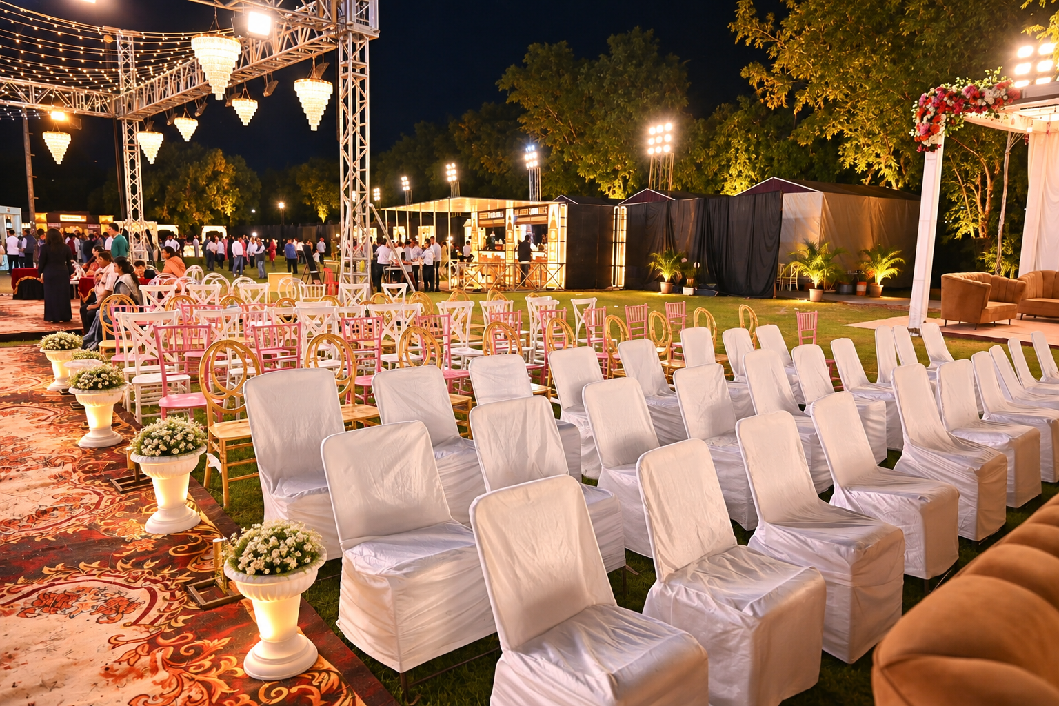 Evening garden celebration with white chair covers, chandeliers and festive lighting